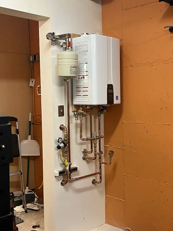 Plumbing technician inspecting water heater connections in San Elizario